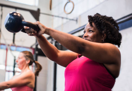 Fit woman over 40 strength training with kettlebell, promoting fitness, mobility, and health in menopause.