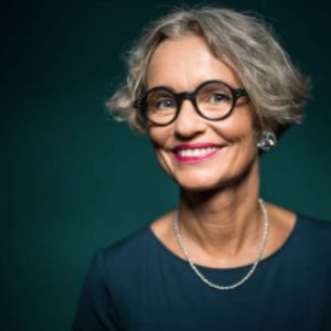 Short Grey haired woman with glasses smiling. Confident woman over 50 with gray hair and glasses, embodying midlife beauty, self-acceptance, and aging with style.